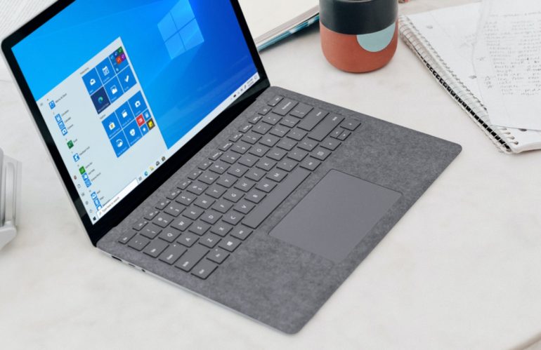 gray microsoft surface laptop computer on white table