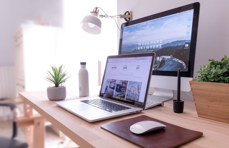 MacBook Pro on table beside white iMac and Magic Mouse