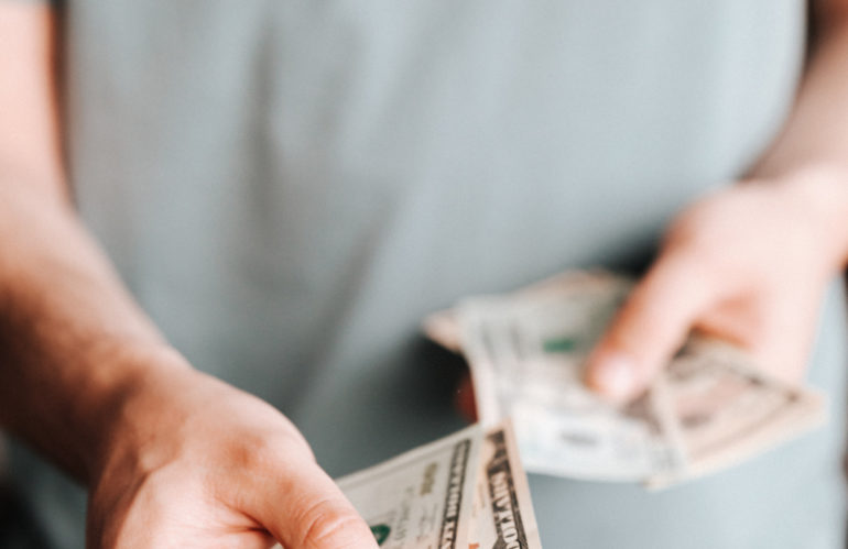 Free Crop man paying with American dollars Stock Photo