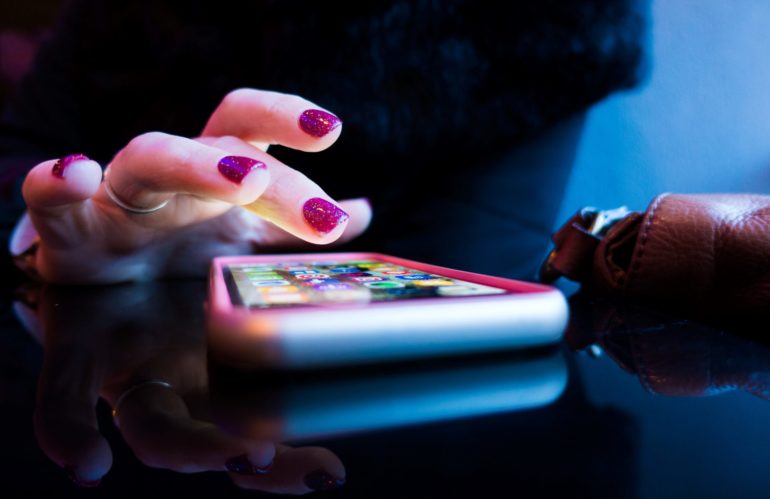 person using black smartphone with gray and pink case