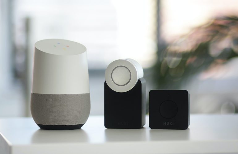 white and gray Google smart speaker and two black speakers