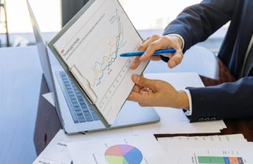 Free Business professionals discussing financial graphs and charts in an office setting. Stock Photo